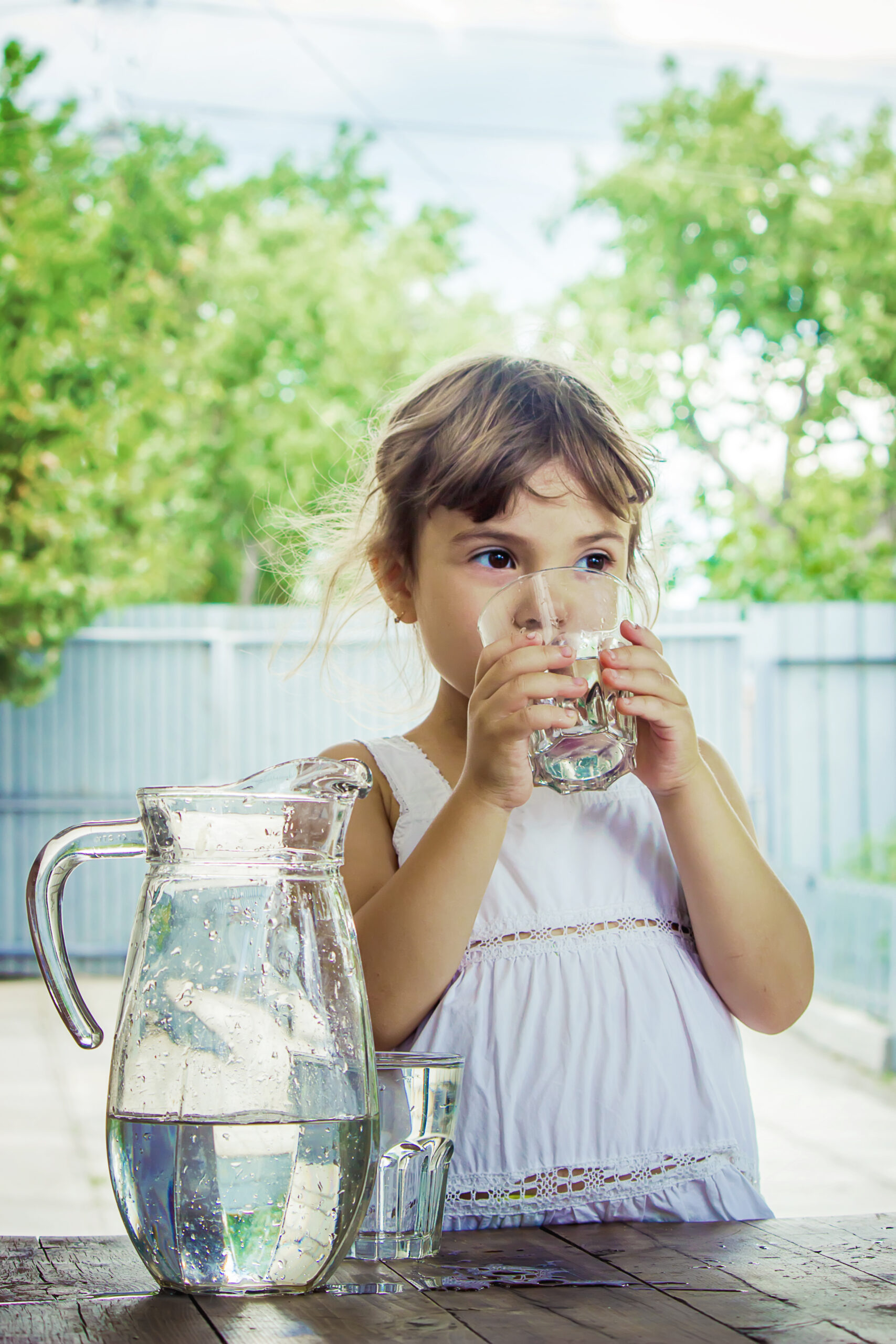 Child drinking clear water from glass